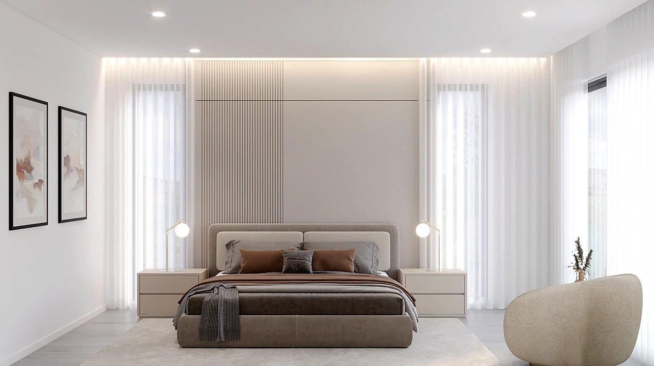 Quarto sofisticado com cama estofada, com duas mesas de cabeceira com candeeiros sutis.