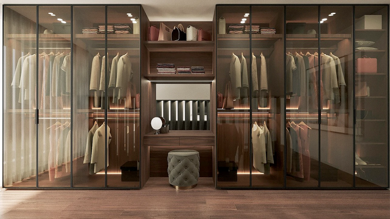 Design elegante de roupeiro por medida com portas de vidro, exibindo roupas de forma sofisticada