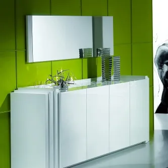 Aparador Strong branco com espelho retangular e objetos decorativos numa parede verde