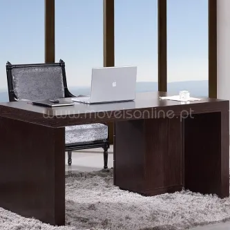 Secretaria de madeira escura com cadeira estofada e portátil prateado