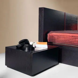 Mesa de cabeceira Simplex preta de madeira com tampo quadrado ao lado de cama escura.