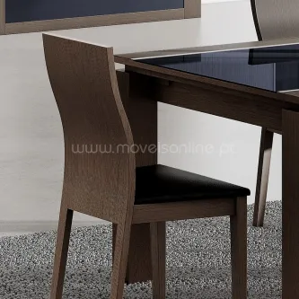 Cadeira Lyon em madeira escura com assento preto e encosto curvo junto a mesa