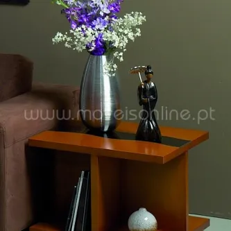 Mesa de apoio em madeira com vaso metálico de flores e objetos decorativos