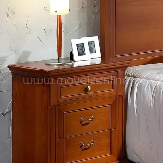 Mesa de cabeceira Luna em madeira castanha com três gavetas ao lado da cama