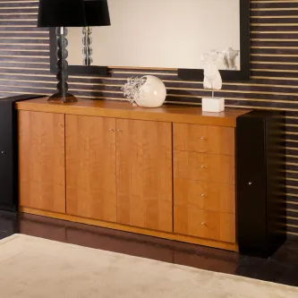 Aparador em madeira clara com quatro portas, gavetas laterais e acessórios decorativos.