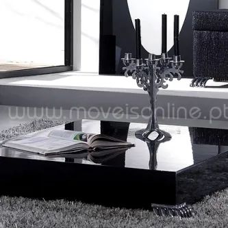 Mesa de centro Vigo preta, baixa e lacada, tampo espelhado com livro aberto e candelabro.
