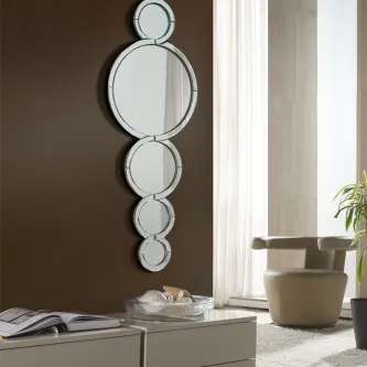 Espelho Mercury vertical composto por cinco círculos espelhados sobre cómoda junto a janela