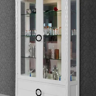 Vitrine glam branca com portas de vidro e prateleiras com copos e objetos