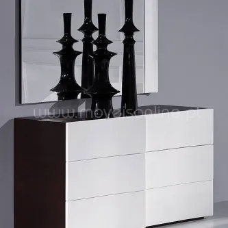 Cómoda branca com moldura escura e vasos decorativos negros no tampo