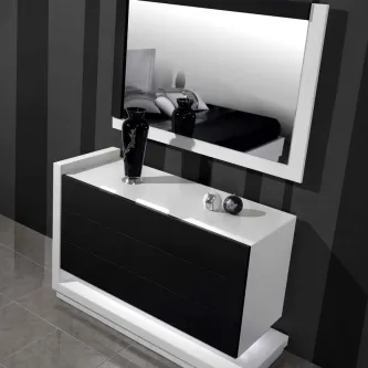 Cómoda branca e preta com espelho retangular, vaso e objetos decorativos sobre tampo