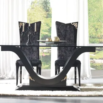 Cadeira Classic preta estofada com encosto alto e detalhes dourados junto a mesa de jantar