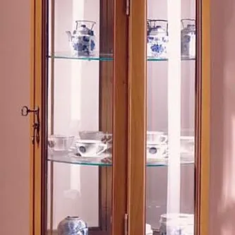 Vitrine meia lua em madeira com portas de vidro e prateleiras exibindo chávenas e vasos