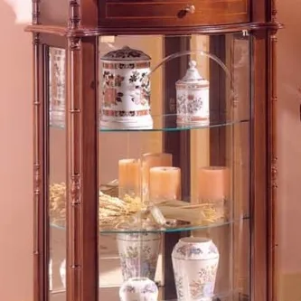 Vitrine coluna em madeira com prateleiras de vidro e vasos e velas decorativas