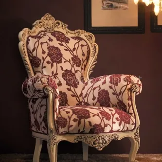 Cadeirão San Juan com estofado creme decorado por flores bordô e estrutura de madeira entalhada