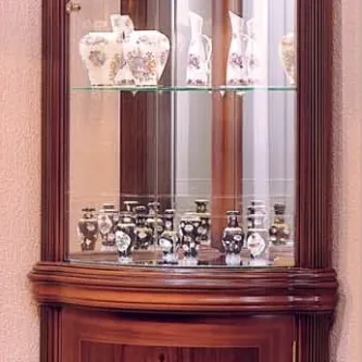 Vitrine Diana canto alta em madeira com portas de vidro e prateleiras com peças decorativas