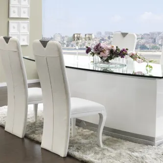 Mesa de jantar Conceição em vidro com cadeiras brancas e vaso de flores