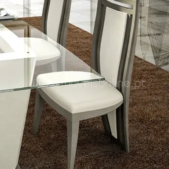 Cadeira Nude 3 estofada em bege claro com estrutura cinzenta junto à mesa de vidro