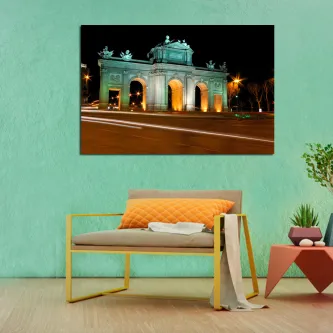 Quadro da Puerta de Alcalá iluminada à noite, pendurado numa parede sobre um sofá