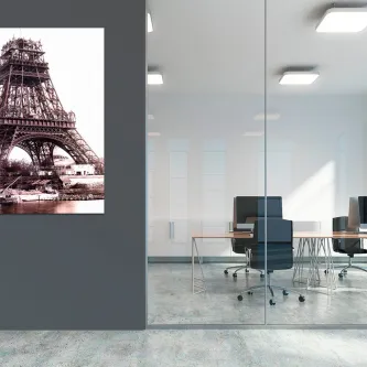 Quadro com imagem da construção da Torre Eiffel numa parede de escritório moderno