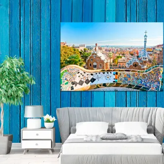 Quadro Parque Guell 2 com mosaicos e vista de Barcelona, pendurado em parede azul acima da cama