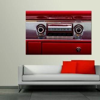 Quadro de rádio vintage vermelho sobre parede, acima de sofá branco com almofadas vermelhas