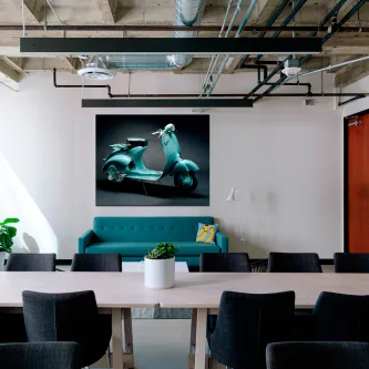 Quadro Vespa com imagem de scooter turquesa na parede de uma sala moderna