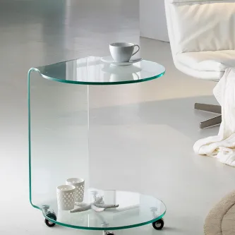 Mesa de apoio redonda em vidro com duas prateleiras circulares e rodas, junto a poltrona