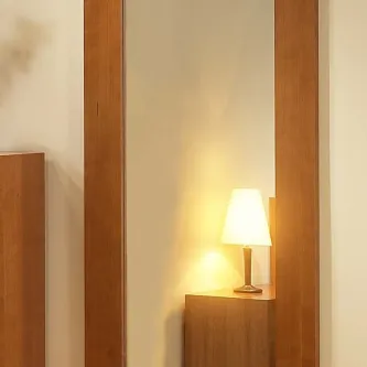 Moldura de parede em madeira refletindo abajur sobre móvel