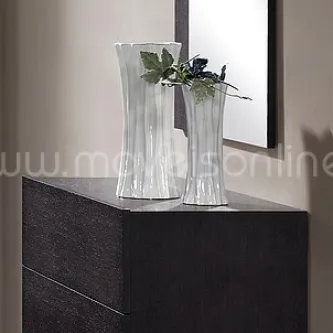 Cómoda Bali escura com duas jarras de vidro e folhagem junto a moldura