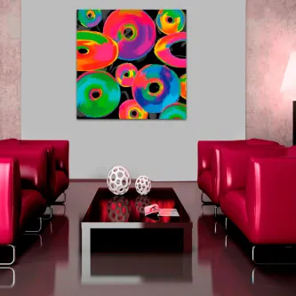 Quadro com donuts coloridos sobre fundo preto na parede de sala com sofás vermelhos