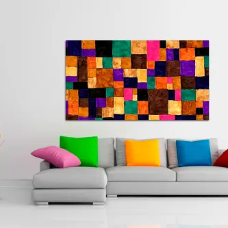 Quadro quadrilhado com blocos coloridos pendurado sobre sofá com almofadas vibrantes
