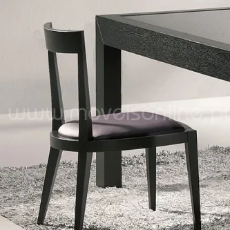 Cadeira Zumb 2010 preta com assento estofado junto a mesa