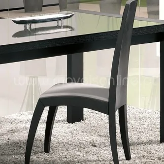 Cadeira Zumb preta junto a mesa de vidro sobre tapete claro