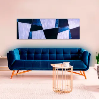 Quadro azulejo azul com padrões geométricos azuis e brancos pendurado sobre sofá azul