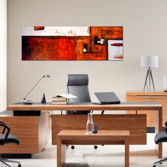 Quadro strong color abstrato laranja e vermelho sobre mesa num escritório moderno
