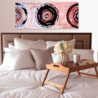 Quadro Zigzagzug com três círculos abstratos em tons de rosa e preto sobre cabeceira de cama