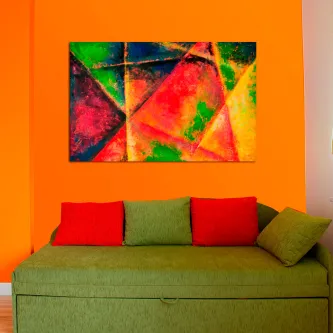 Quadro mistura colorida abstrato com formas triangulares em tons vivos, sobre parede laranja