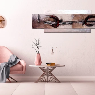 Quadro abstrato 'Costas Voltadas' pendurado sobre mesa baixa com vaso e sofá rosa