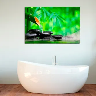Quadro Água em bambu com água a cair de bambu sobre pedras negras e vapor