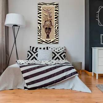 Quadro étnico com riscas de zebra e máscara tribal sobre cama