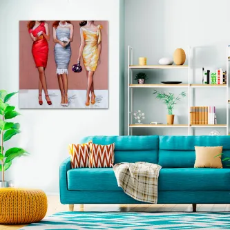 Quadro Elegantemente Vestidas com três mulheres de vestidos coloridos pendurado numa sala moderna