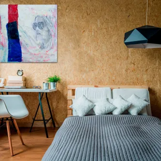 Quarto com cama e quadro de menina com óculos em forma de coração