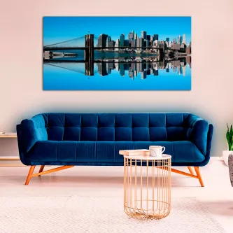 Painel de silhueta urbana com reflexo simétrico sobre sofá azul.