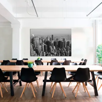 Sala de reunião com mesa e cadeiras e quadro 'Empreendimentos New York' a preto e branco