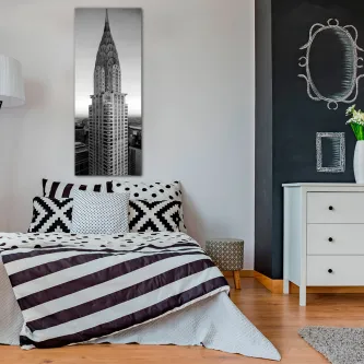 Quadro do edifício Chrysler em preto e branco acima de cama num quarto moderno