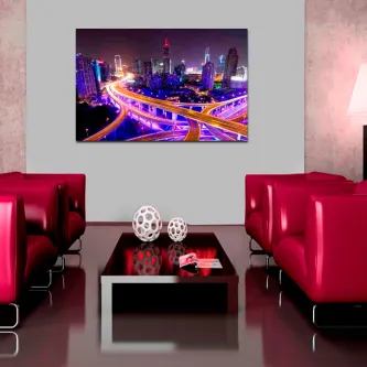 Sala com sofás vermelhos e quadro 'Cidade Moderna' de cidade nocturna iluminada