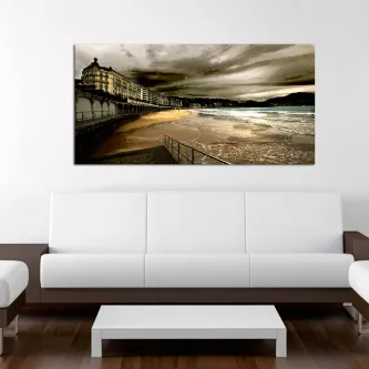 Passeio marítimo e praia no País Basco com edifícios históricos e céu nublado