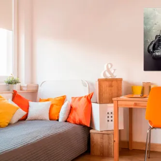 Quadro Box com luva de boxe preto e branco na parede acima da cama com almofadas laranja
