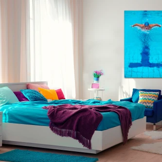 Quarto juvenil com cama azul e quadro natação de nadador a mergulhar na parede