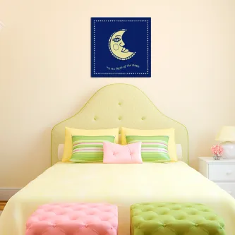 Quadro 'Lado da Lua' com lua crescente sorridente em fundo azul pendurado sobre cama